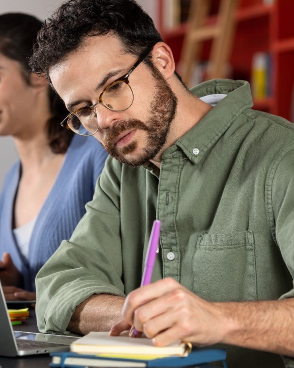 Alumno tomando notas en una clase de formación oficial gratuita en Oleiros, A Coruña